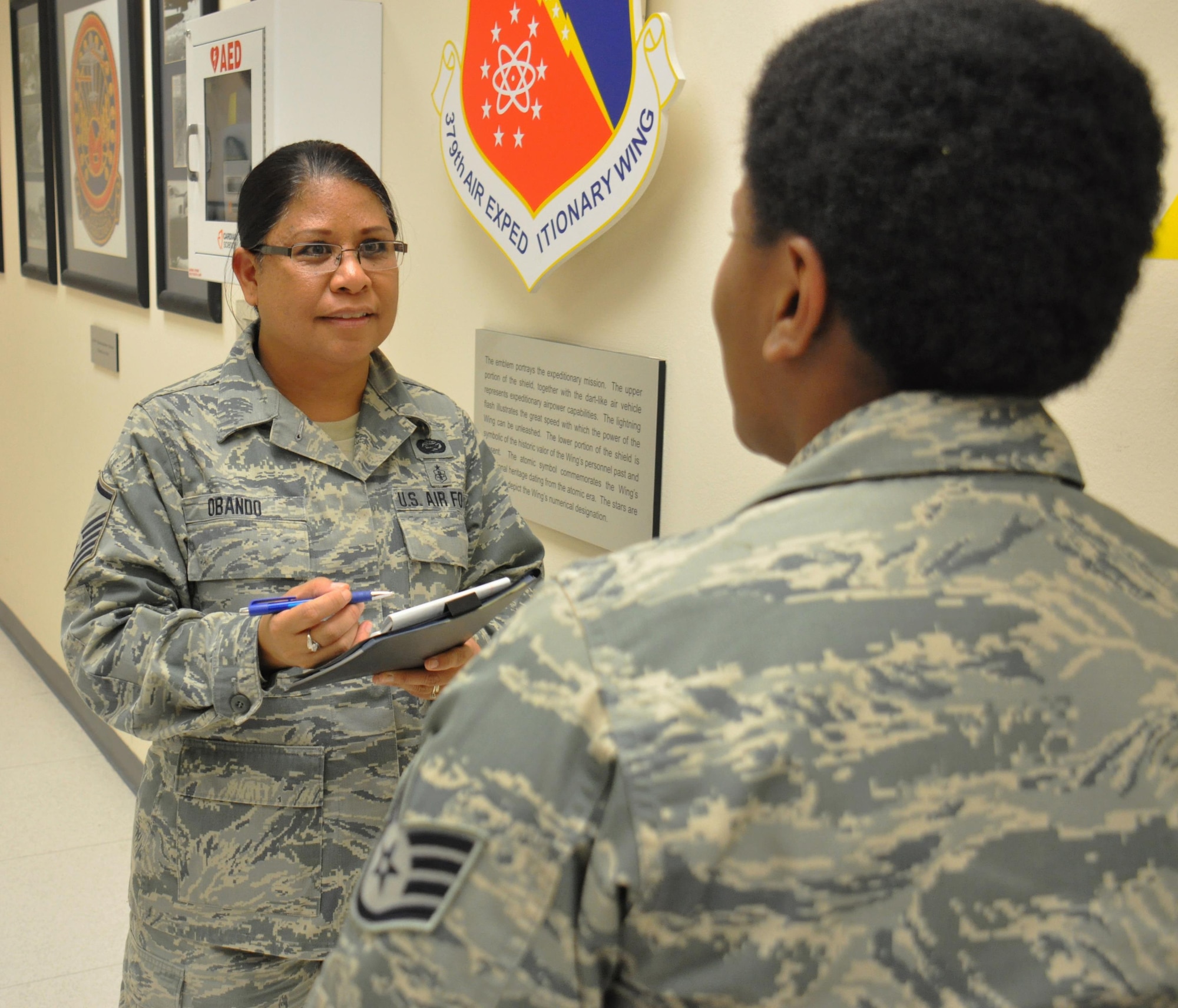Master Sgt. Janine Obando, 379th Air Expeditionary Wing Equal Opportunity director from Ewa, Hawaii, meets with Staff Sgt. Yolanda Jackson, 379 AEW Protocol noncommissioned officer in charge from Chicago,  at the Wing Operations Center at Al Udeid Air Base, Qatar, Jan. 21. Obando said it's important for her to meet with service members across AUAB to foster trust between units and the EO office. Jackson and Obando discussed different aspects of the protocol mission during the meeting. (U.S. Air Force photo by Tech. Sgt. James Hodgman/Released)