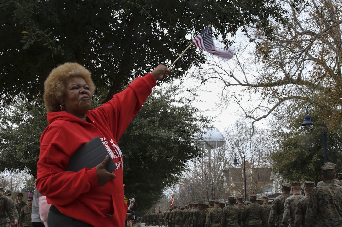 Judy Muqtasid, a local resident, welcomes Marines and sailors into Riverwalk Crossing Park during the 2nd Marine Division’s 75th anniversary parade in downtown Jacksonville, N.C., Feb. 6, 2016. The celebration serves as a time to remember the Marines and sailors who served and continue to serve in 2nd Marine Division, while thanking the local community for their support. (U.S. Marine Corps photo by Cpl. Paul S. Martinez/Released)