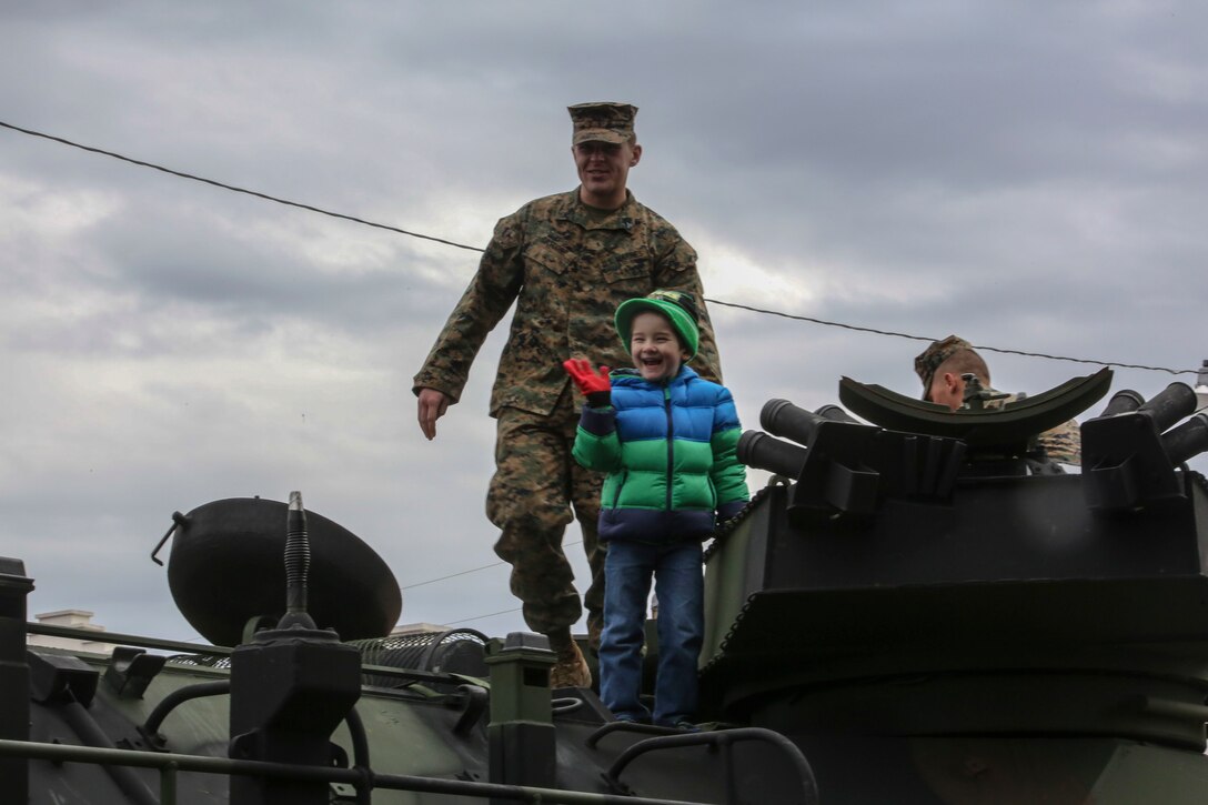 Corporal Nicholas J. Cascone, an assault amphibious vehicle crewman with 2nd Assault Amphibian Battalion, and Lucas Lynn, son of Matthew Lynn, a Jacksonville resident, stand atop an AAV following the 2nd Marine Division’s 75th anniversary parade in downtown Jacksonville, N.C., Feb. 6, 2016. The celebration serves as a time to remember the Marines and sailors who served and continue to serve in 2nd Marine Division, while thanking the local community for their support. (U.S. Marine Corps photo by Cpl. Paul S. Martinez/Released)