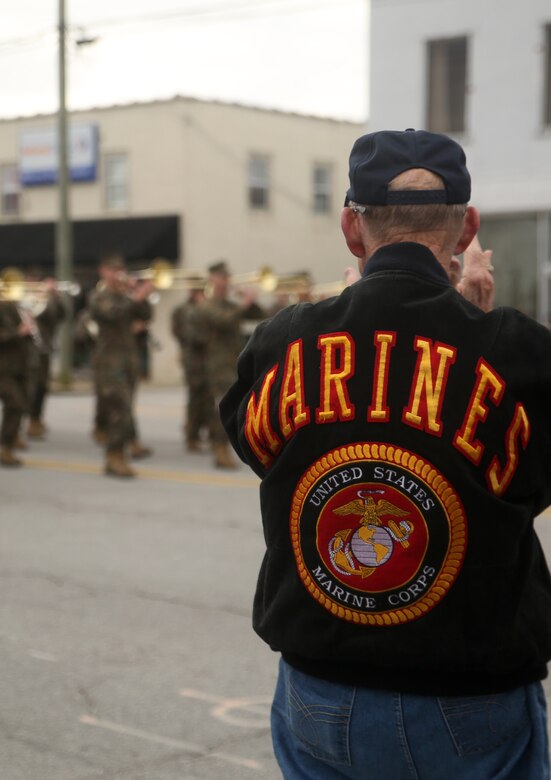 A former Marine claps as active-duty service members with 2nd Marine Division march in the Division’s 75th anniversary parade in downtown Jacksonville, N.C., Feb. 6, 2016. The celebration serves as a time to remember the Marines and sailors who served and continue to serve in 2nd Marine Division, while thanking the local community for their support. (U.S. Marine Corps photo by Cpl. Joey Mendez/Released)