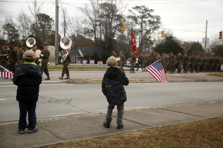 A young boy watches as Marines and sailors with 2nd Marine Division march by in the unit’s 75th anniversary parade in downtown Jacksonville, N.C., Feb. 6, 2016. The celebration serves as a time to remember the Marines and sailors who served and continue to serve in 2nd Marine Division, while thanking the local community for their support. (U.S. Marine Corps photo by Cpl. Joey Mendez/Released)