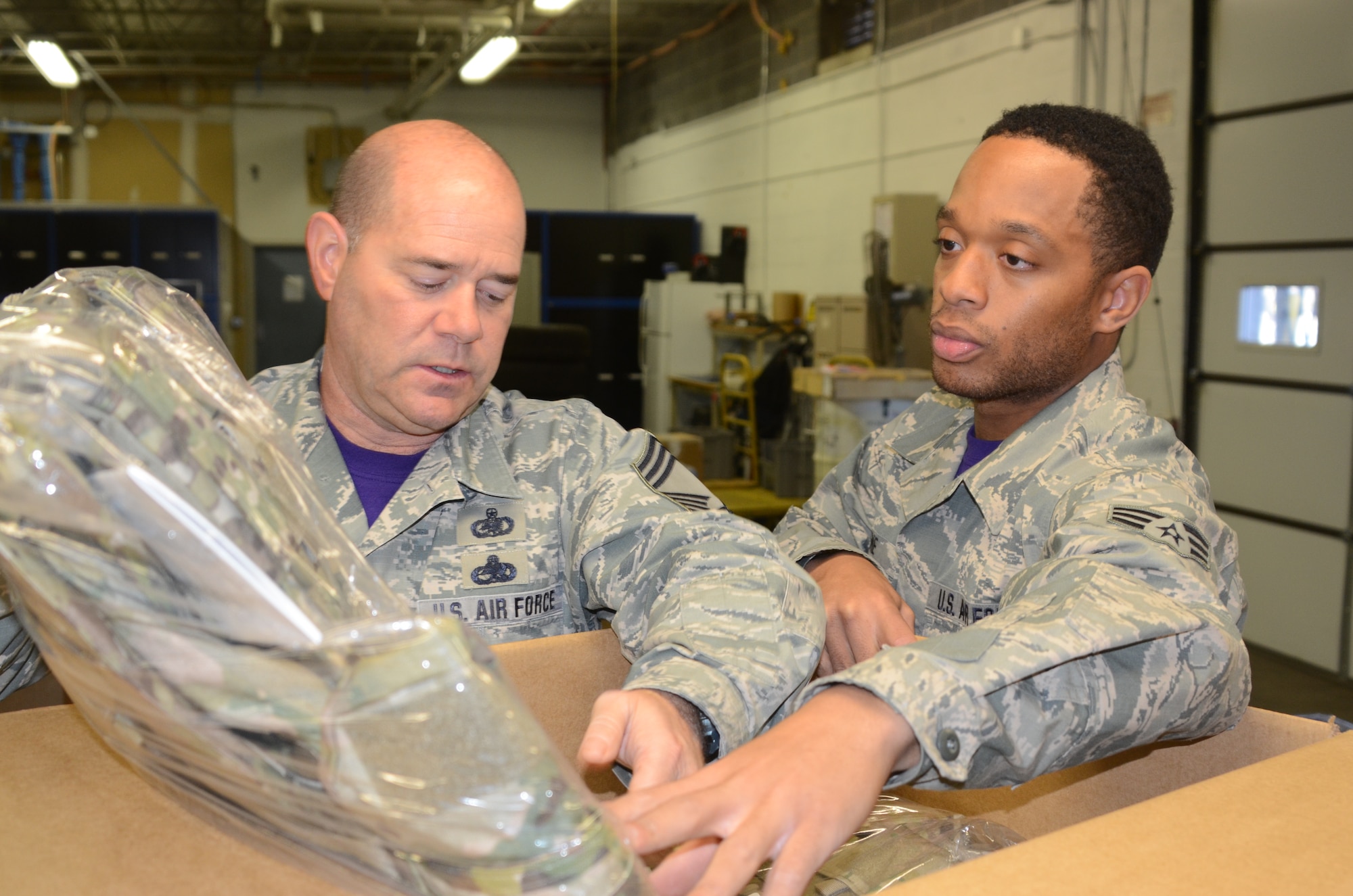 Chief Master Sgt.David Liberto, right, and Senior Airman William Greene IV, both of whom are assingned to the 175th Logistic Readiness Squadron, unpack new Air Force equipment at Warfield Air National Guard Base in Baltimore Dec. 4, 2015. Green, who processes inbound parcels for the entire base, was selected as the Spotlight Airman for the month of February in the Maryland Air National Guard. (U.S. Air National Guard photo by Tech. Sgt. David Speicher/RELEASED)