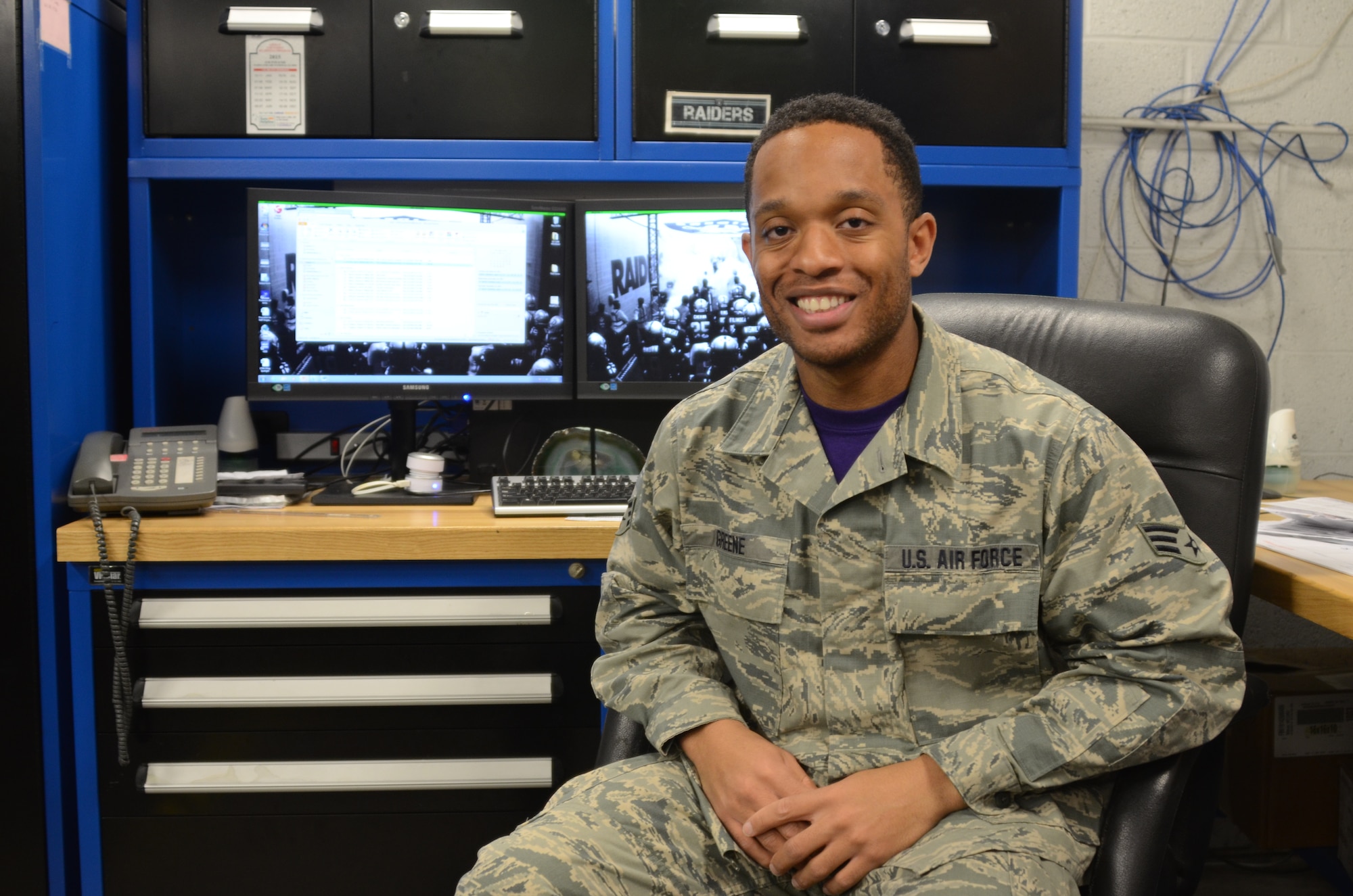 Cutline:  Senior Airman William Greene IV, assigned to the traffic management office, 175th Logistic Readiness Squadron, poses at his desk in the supply warehouse at Warfield Air National Guard Base in Baltimore Dec. 4, 2015. Green, who processes inbound parcels for the entire base, was selected as the Spotlight Airman for the month of February in the Maryland Air National Guard. (U.S. Air National Guard photo by Tech. Sgt. David Speicher/RELEASED)