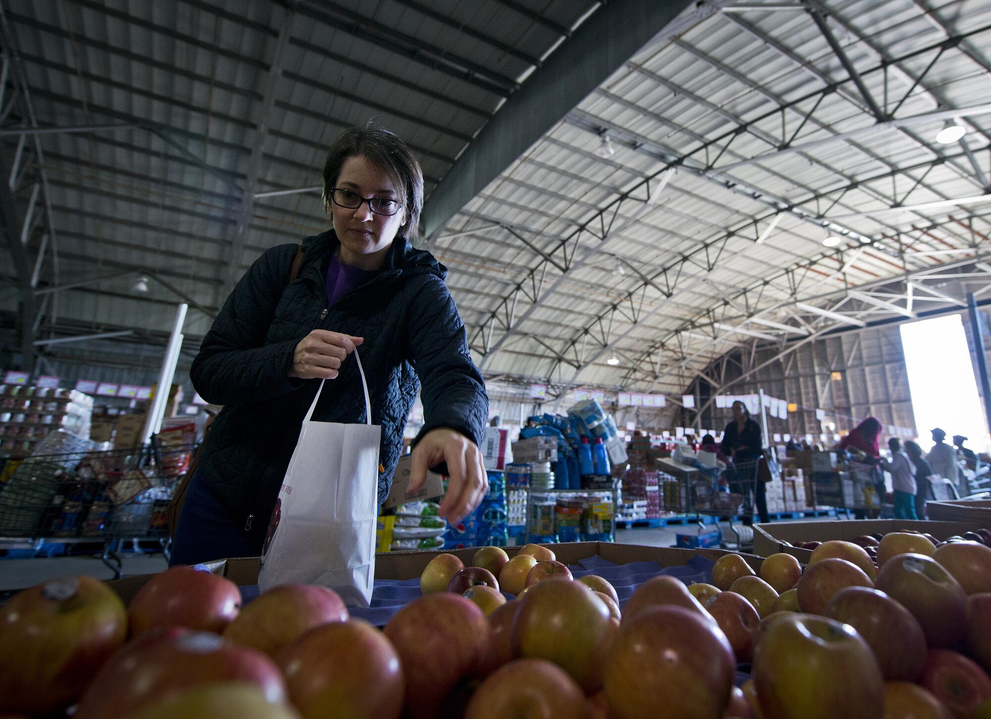A shopper reaches for another apple while waiting in line to pay inside the commissary case lot sale at Duke Field, Fla., Feb. 6. Patrons waited in line for at least 30 minutes to receive the special sales prices. The two-day sale was open to military, retirees, family members and had special hours for reservists. (U.S. Air Force photo/Tech. Sgt. Sam King)