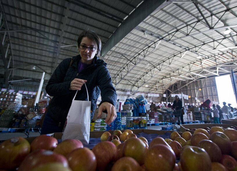 A shopper reaches for another apple while waiting in line to pay inside the commissary case lot sale at Duke Field, Fla., Feb. 6. Patrons waited in line for at least 30 minutes to receive the special sales prices. The two-day sale was open to military, retirees, family members and had special hours for reservists. (U.S. Air Force photo/Tech. Sgt. Sam King)