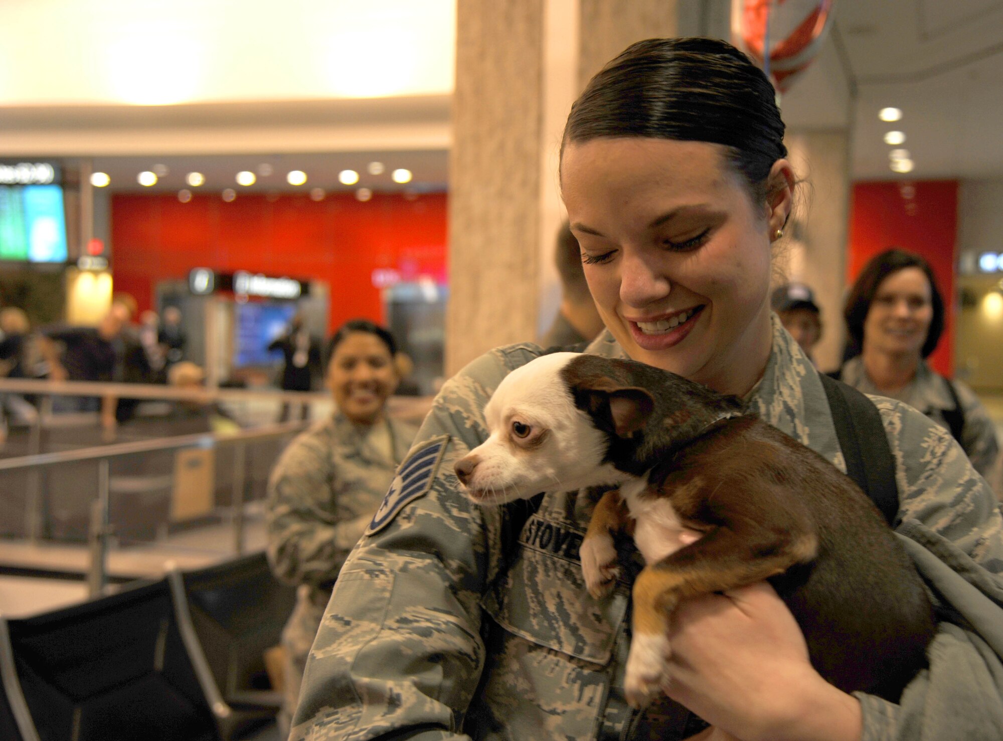 Staff Sgt. Marissa Stover, 45th Aeromedical Evacuation Squadron commander support staff, hugs her dog after arriving from a deployment on Feb. 5, 2016 at Tampa International Airport. Stover was part of personnel who arrived after serving four months overseas, assisting injured service men and women. (U.S. Air Force photo by Tech. Sgt. Peter Dean) 