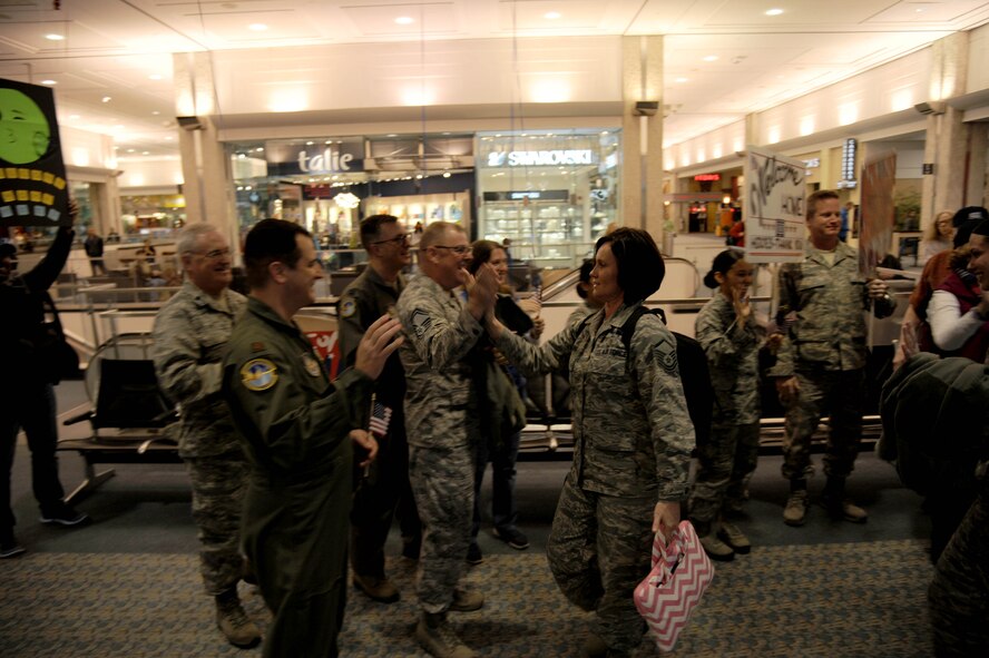 Members of the 45th Aeromedical Evacuation Squadron celebrate the arrival of deployed members on Feb. 5, 2016 at Tampa International Airport. Personnel arrived after serving four months overseas, assisting injured service men and women. (U.S. Air Force photo by Tech. Sgt. Peter Dean) 