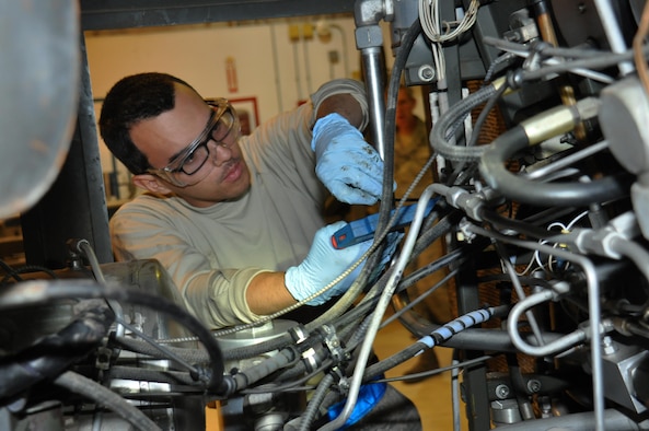 Airman 1st Class Gavin Baker, 379th Expeditionary Maintenance Squadron Aerospace Ground Equipment Flight mechanic from Lancaster, California, zip ties a chaff-wrap inside a hydraulics- test stand at Al Udeid Air Base, Qatar, Feb. 4. Zip-tying the wires helps prevent damage that could be caused by vibrations. The hydraulics-test stand is used to test various hydraulic components on aircraft. (U.S. Air Force photo by Tech. Sgt. James Hodgman/Released)