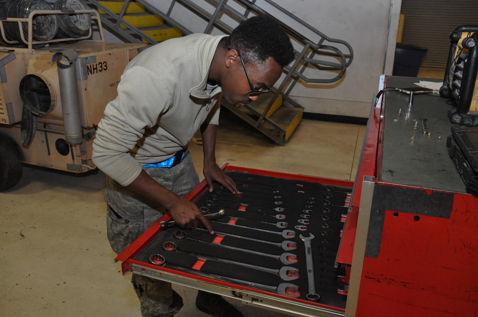 Airman 1st Class Michael Higgins, 379th Expeditionary Maintenance Squadron Aerospace Ground Equipment mechanic from New York, searches for tools to work on a new generation heater inside the AGE Flight facility at Al Udeid Air Base, Qatar Feb. 4. The flight maintains more than 90 different types of tools and equipment valued at $32 million. (U.S. Air Force photo by Tech. Sgt. James Hodgman/Released)