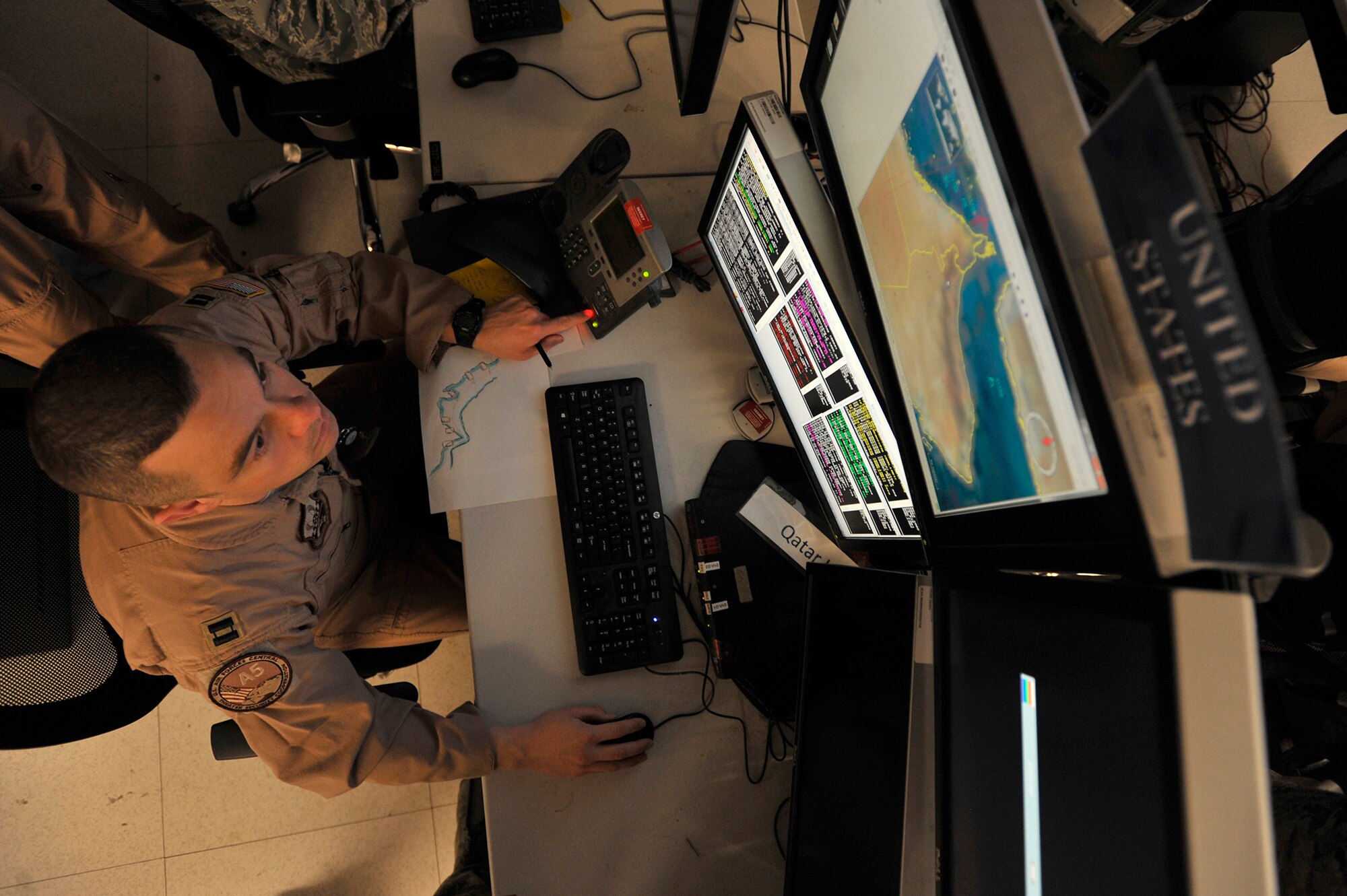 Capt. Kristopher Williams, exercise director, orchestrates the exercise simulation during Arabian Gulf Shield, Feb. 3, 2016, in the Combined Air Operations Center, Al Udeid Air Base, Qatar. Arabian Gulf Shield is the culminating exercise for the Gulf Cooperation Council (GCC) Liaison Officer (LNO) Program. The exercise is designed to exercise GCC LNO procedures and connectivity to host nation Air Operations Centers which improves US-GCC interoperability. (U.S. Air Force photo by Master Sgt. Joshua Strang)