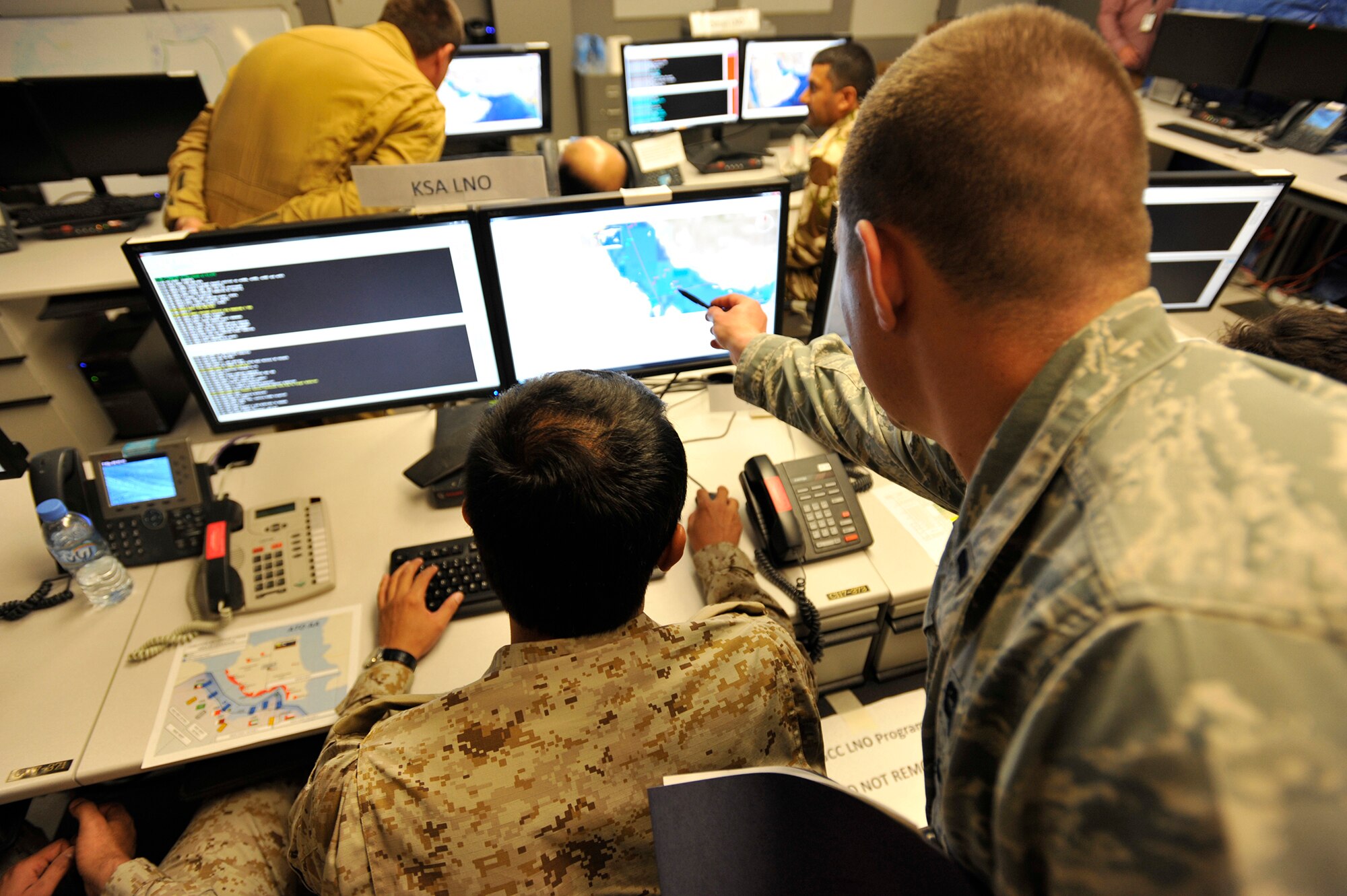 1st Lt. Joshua Skoglund, exercise coordinator, assists a Royal Saudi Air Forces' Liaison Officer (LNO) student during Arabian Gulf Shield, Feb. 3, 2016, in the Combined Air Operations Center, Al Udeid Air Base, Qatar. Arabian Gulf Shield is the culminating exercise for the Gulf Cooperation Council (GCC) LNO Program. The exercise is designed to exercise GCC LNO procedures and connectivity to host nation Air Operations Centers which improves US-GCC interoperability. (U.S. Air Force photo by Master Sgt. Joshua Strang)