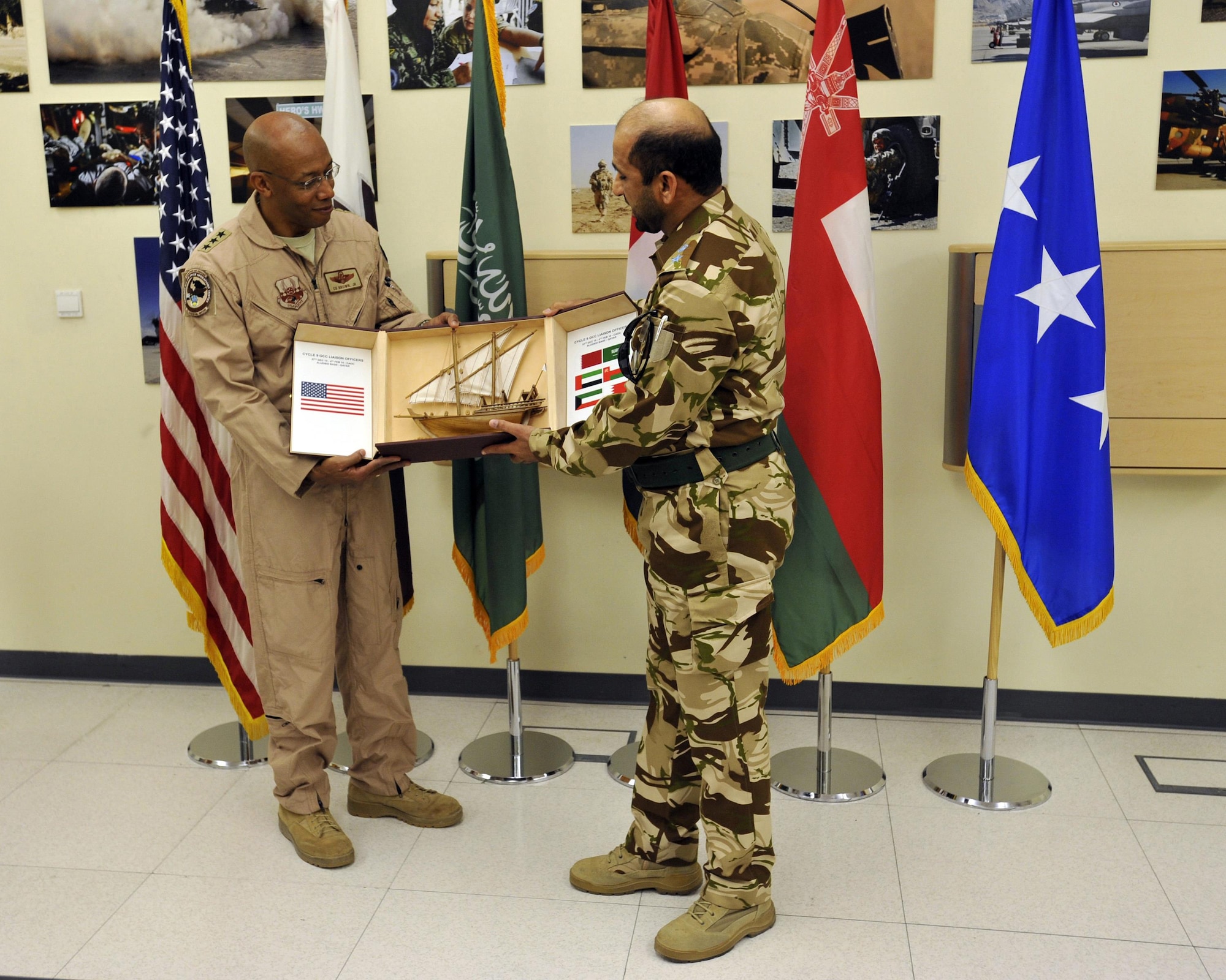 Royal Air Force of Oman Wing Commander Rashid Al-Shidi presents Lt. Gen. Charles Q. Brown, commander, U.S. Air Forces Central Command, a momento during a graduation ceremony, Feb. 4, 2016, in the Combined Air Operations Center, Al Udeid Air Base, Qatar. The ceremony recognized the achievement of the students completion of the Gulf Cooperation Council (GCC) Liaison officer Program and the Senior Operations Planner Program. Both programs improve interoperability and furthers relations within the GCC and the U.S. air and air defense community. (U.S. Air Force photo by Master Sgt. Joshua Strang)