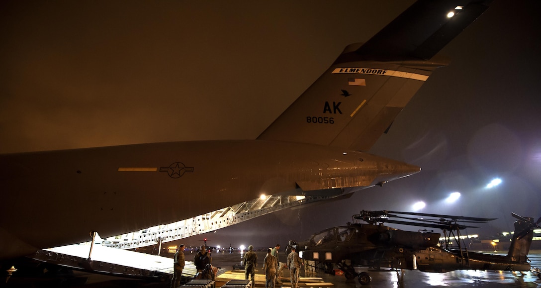 Soldiers and airmen work together to load an AH-64 Apache helicopter onboard a C-17 Globemaster III in support of large package week operations on Pope Army Airfield, N.C., Feb. 4, 2016. Air Force photo by Staff Sgt. Paul Labbe