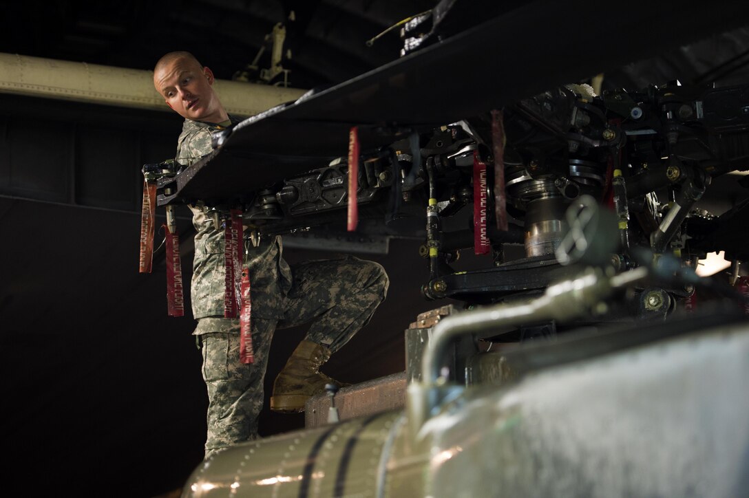 Soldiers and airmen work together to load an AH-64 Apache helicopter onboard a C-17 Globemaster III in support of large package week operations on Pope Army Airfield, N.C., Feb. 4, 2016. Air Force photo by Staff Sgt. Paul Labbe