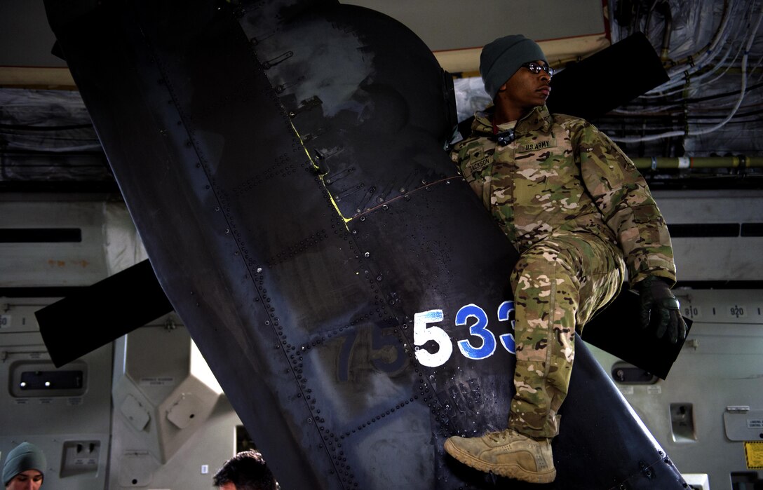 An Army specialist works on the tail rotor of an AH-64 Apache helicopter after being loaded up inside a C-17 Globemaster III in support of large package week operations on Pope Army Airfield, N.C., Feb. 4, 2016. Jackson is assigned to the 82nd Airborne Division’s 82nd Combat Aviation Brigade. Air Force photo by Staff Sgt. Paul Labbe