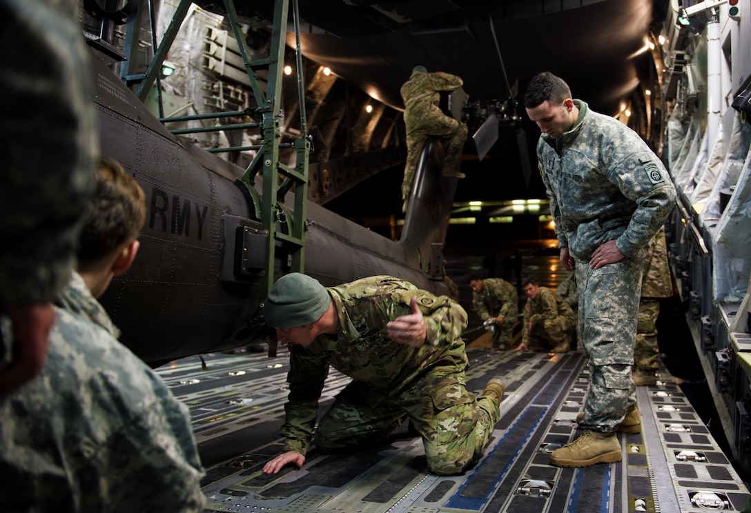 Soldiers and airmen work together to secure an AH-64 Apache helicopter onboard a C-17 Globemaster III in support of large package week operations on Pope Army Airfield, N.C., Feb. 4, 2016. Air Force photo by Staff Sgt. Paul Labbe