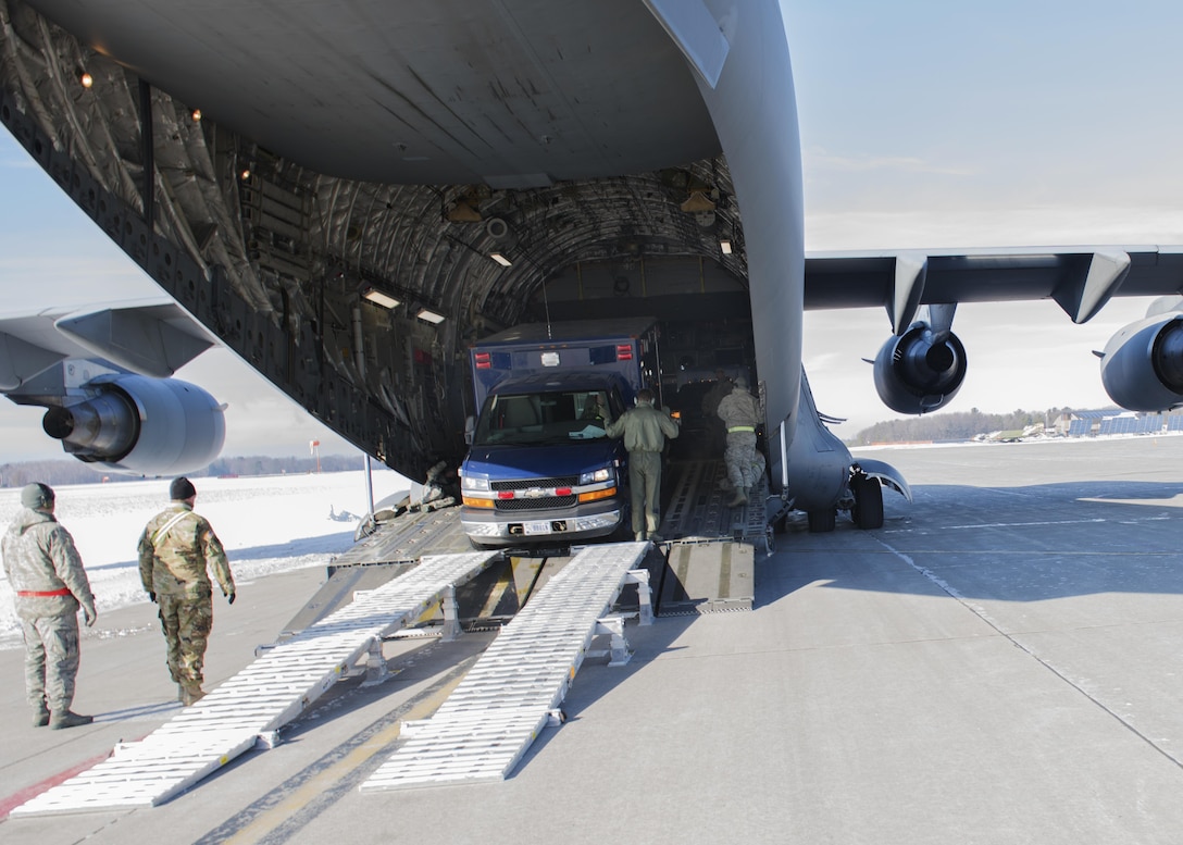 Soldiers and airmen load a vehicle onto a C-17 Globemaster as they prepare to fly to Puerto Rico for a training evaluation, Jan 24, 2016. Vermont Army National Guard photo by Staff Sgt. Nathan Rivard