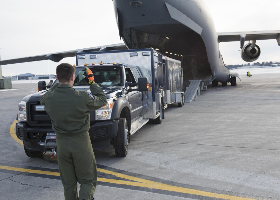 Soldiers and airmen load a vehicle onto a C-17 Globemaster as they prepare to fly to Puerto Rico for a training evaluation, Jan 24, 2016. Vermont Army National Guard photo by Staff Sgt. Nathan Rivard