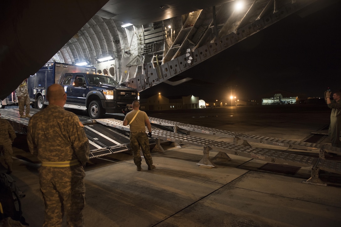 Soldiers and airmen unload vehicles from a C-17 Globemaster in Carolina, Puerto Rico, Jan. 24, 2016. The soldiers and airmen are assigned to the Vermont National Guard’s 15th Civil Support Team. This is the first time the unit has airlifted to Puerto Rico for a training proficiency evaluation. Vermont Army National Guard photo by Staff Sgt. Nathan Rivard