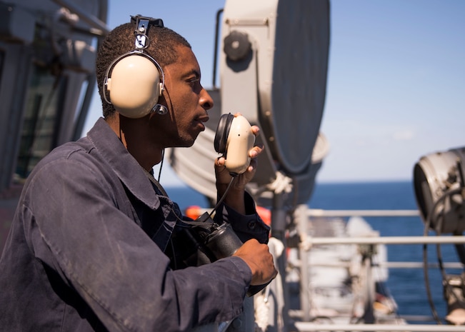 (Feb. 1, 2016) Boatswain's Mate Seaman Recruit Darry Hicks, from Chicago, relays messages through a sound-powered telephone on the signal bridge aboard the amphibious assault ship USS Kearsarge (LHD 3). Kearsarge is the flagship for the Kearsarge Amphibious Ready Group (ARG) and, with the embarked 26th Marine Expeditionary Unit (MEU), is deployed in support of maritime security operations and theater security cooperation efforts in the U.S. 5th Fleet area of operations.