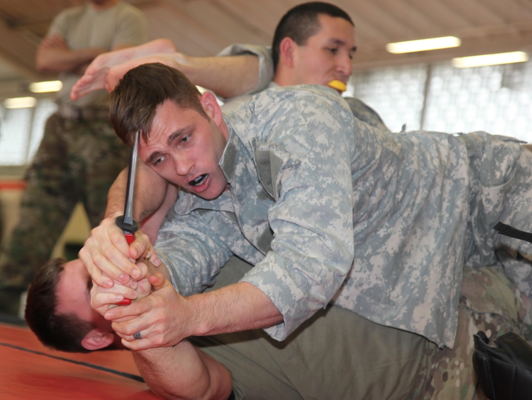 KAISERSLAUTERN, Germany-Staff Sgt. Joshua Barnes tries to control a ‘Shocknive,’ an electronic training knife, during the 7th Mission Support Command/21st Theater Sustainment Command led tactical combatives course Feb. 4, 2016 at Kleber Fitness Center. Barnes, a member of the 92nd Military Police Company and other students were participating in the culminating event of a two-week long tactical combatives training.