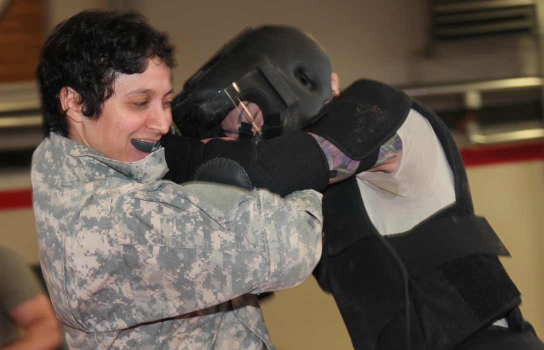 KAISERSLAUTERN, Germany-Sgt. Vanessa Carrillo, left, pulls Spc. Misty Valandingham, in the High-Gear Suit, to the ground during battle drills at the 7th Mission Support Command led tactical combatives course Feb. 4, 2016 at Kleber Fitness Center. Carrillo, a member of the 515th Transportation Company and Valandingham, a member of the 92nd Military Police Company and other students were participating in the culminating event of a two-week long tactical combatives training.