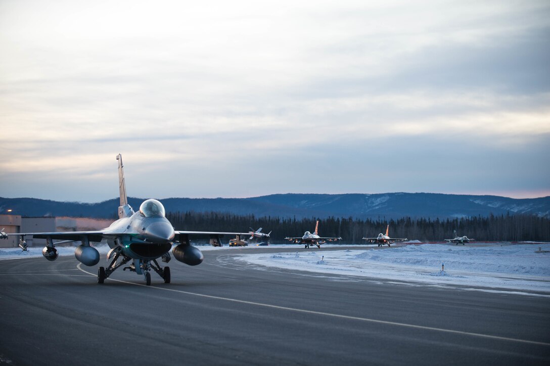 An Air Force F-16 Fighting Falcon aircraft taxi to the flightline on Eielson Air Force Base, Alaska, Jan. 24, 2016, to fly to Kadena Air Base, Japan, to participate in training exercises. The pilots are assigned to the 18th Aggressor Squadron. Air Force photo by Staff Sgt. Shawn Nickel