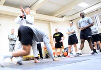 Professor Luis Alejandre demonstrates how to roll over an opponent with Sensei Frank Roman during a Brazilian Jujitsu training session at Forest Park Armed Forces Reserve Center Feb. 6, 2016.
