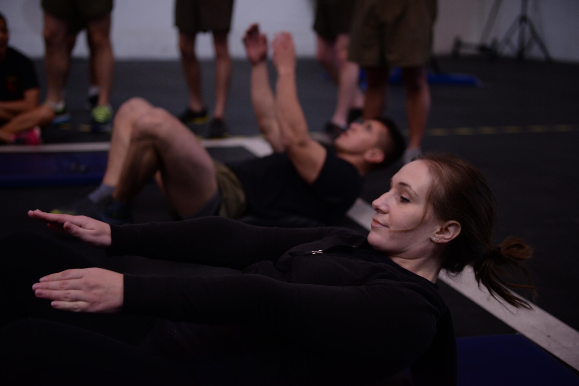 Jemia Fournier, fitness center sport specialist, competes against a Marine to complete the most sit-ups during the squadron PT challenge, Feb. 5, 2016, at the Luke Bryant Fitness Center. Teams competed during the event by rotating through members to complete a series of exercises in the fastest time. 