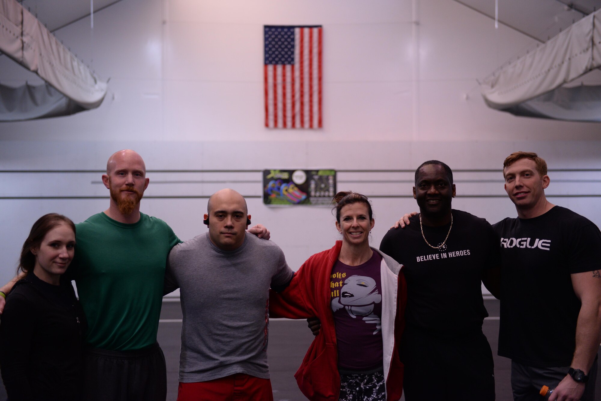 The Bryant Fitness Center team poses in front of the flag in the fitness center Combat PT tent following the anaerobic portion of the squadron PT challenge, Feb. 5, 2016. The Fitness Center team was composed of trainers, staff, and Airmen. 