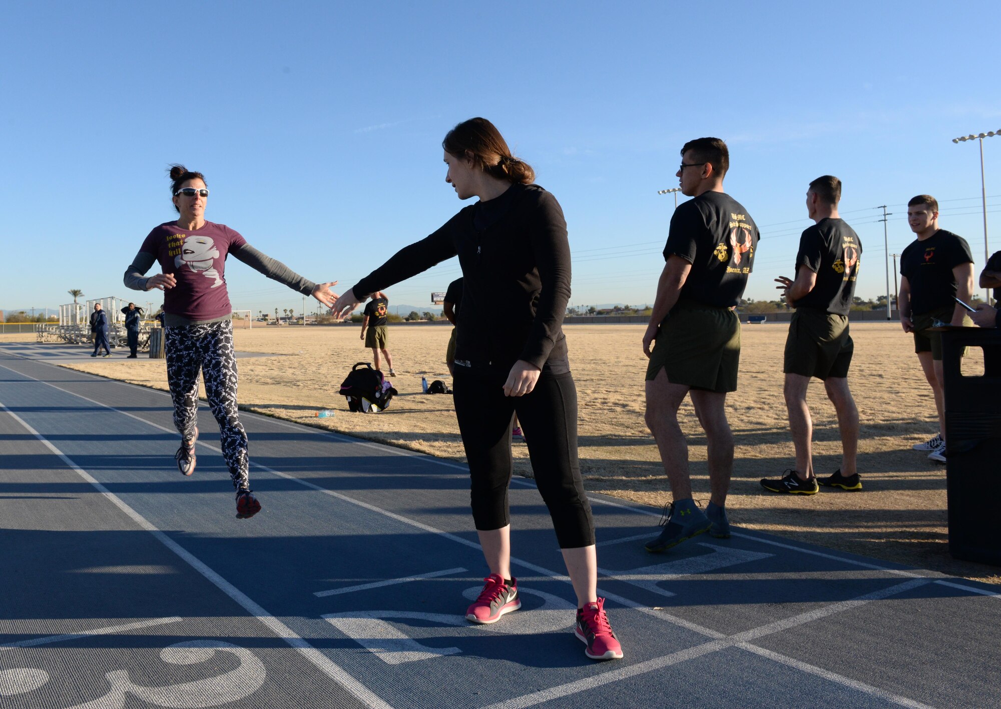Sherri Biringer, fitness center fitness specialist supervisor, closes the last few feet of her lap before tapping-in her sprinting partner, Jemia Fournier, fitness center sport specialist, during the relay race portion of the squadron PT challenge, Feb. 5, 2016, at Luke Air Force Base. The year’s first squadron PT challenge pitted a team of Airmen and employees from the Bryant Fitness Center against a team of Marines from the 6th Engineer Support Battalion.