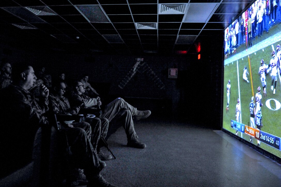 Service members and civilian contractors watch the Denver Broncos and Carolina Panthers compete in Super Bowl 50 during a viewing party at Bagram Airfield, Afghanistan, Feb. 8, 2016. Miami Dolphins cheerleaders and former players joined troops at Bagram for the event. Air Force photo by Tech. Sgt. Nicholas Rau