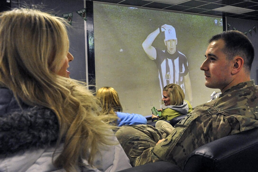 A service member talks with a Miami Dolphins cheerleader during a Super Bowl 50 viewing party at Bagram Airfield, Afghanistan, Feb. 8, 2016. Air Force photo by Tech. Sgt. Nicholas Rau