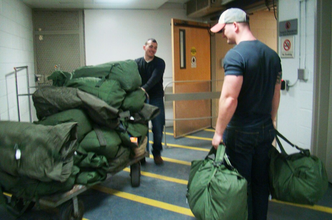 1st Lt. Craig Muma and Sgt. Zachary Grissom help move duffle bags of clothes in preparation for the 2016 Winterhaven Homeless Veteran Stand-Down at the Washington D.C. VA Medical Center. The event is held to distribute winter
wear to local homeless veterans. 
