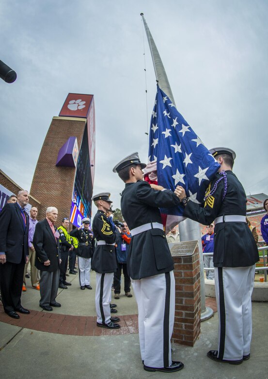 The Clemson University Reserve Officer Training Corps honor guard, the Pershing Rifles, raises the American flag on the Memorial Stadium flagpole as U.S. Army Col. (retired) Ben Skardon (left), 98, a Bataan Death March survivor, watches, Nov. 21, 2015. The ceremony permanently dedicated the flagpole to Skardon, a Clemson alumnus and professor emeritus. (U.S. Army photo by Staff Sgt. Ken Scar)