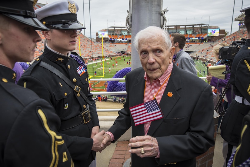 U.S. Army Col. Ben Skardon (retired), a WWII veteran and survivor of the Bataan Death March, greets cadets of Clemson University's Reserve Officers Training Corps at the base of a flagpole that had just been named in his honor, Nov. 21, 2015. (U.S. Army photo by Staff Sgt. Ken Scar)