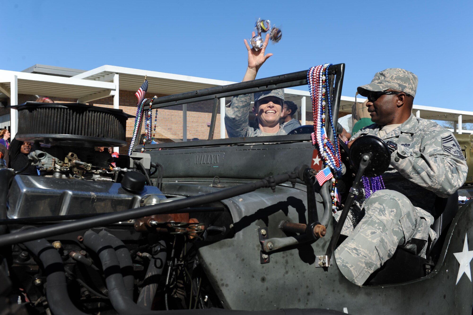 Col. Michele Edmondson, 81st Training Wing commander, throws snack cakes to the crowd during the Jeff Davis Elementary School Mardi Gras Parade, Feb. 5, 2016, Biloxi, Miss. Edmondson and Chief Master Sgt. Harry Hutchinson, 81st TRW command chief, served as Grand Marshalls for the event. (U.S. Air Force photo by Kemberly Groue)