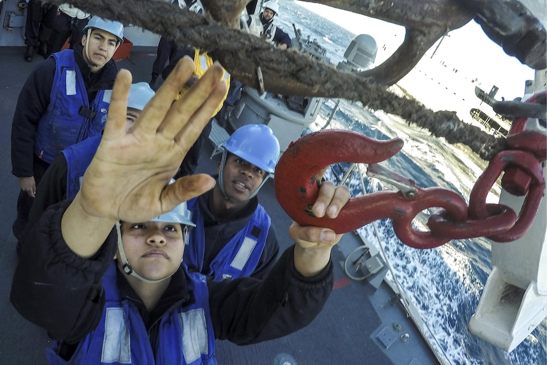 Navy Seaman Lisette Longoria connects the surf hook during a replenishment aboard the USS Carney in the Mediterranean Sea, Feb. 7, 2016. The guided-missile destroyer is supporting U.S. national security interests in Europe. U.S. Navy photo by Petty Officer 1st Class Theron J. Godbold