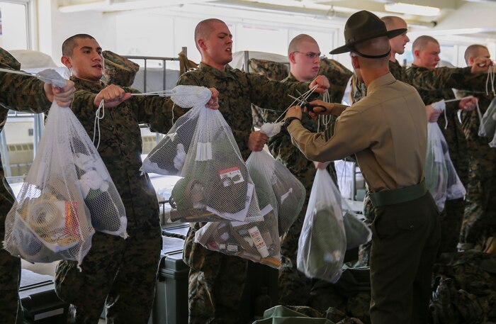 A drill instructor of Golf Company, 2nd Recruit Training Battalion, cuts the strings off recruits’ laundry bags during pick up at Marine Corps Recruit Depot San Diego, Feb. 5. In the first hours recruits are with their drill instructors, they learn the rules and regulations of recruit training, covering everything from how to act in the squad bay to how to speak to the drill instructors. Annually, more than 17,000 males recruited from the Western Recruiting Region are trained at MCRD San Diego. Golf Company is scheduled to graduate April 29.