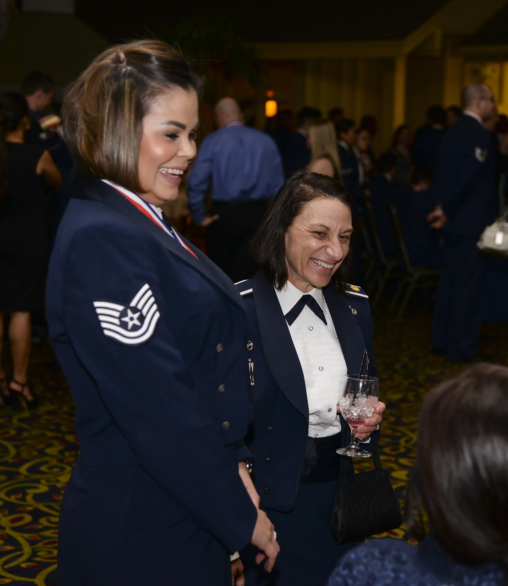 Technical Sgt. Tania Mitchell, 790th Maintenance Squadron, and Maj. Jacquie Sartori, 790th MXS commander, speak with a friend during the social hour of the F.E. Warren Air Force Base 90th Missile Wing 2015 Annual Awards Ceremony Feb. 5, 2016, in the Cheyenne, Wyo., Holiday Inn. Mitchell won the non-commissioned officer of the year award. (U.S. Air Force photo by Senior Airman Jason Wiese)