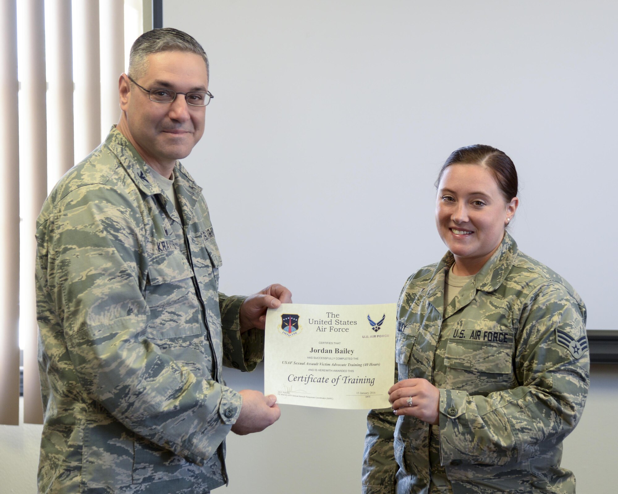 Senior Airman Jordan Bailey, 790th Missile Security Forces Squadron commander’s support staff, poses for a photo with Col. Stephen Kravitsky, 90th Missile Wing commander, Jan. 26, 2016, on F.E. Warren Air Force Base, Wyo. Bailey received a certificate of completion of training to become a victim advocate for the 90th MW Sexual Assault Prevention and Response Office. (U.S. Air Force photo by Senior Airman Jason Wiese)