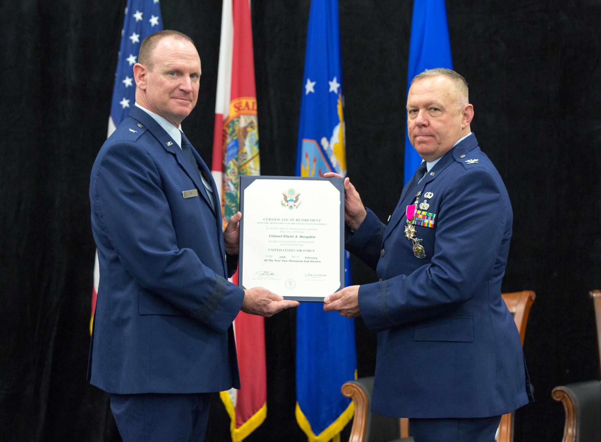 Brig. Gen Christian G. Funk, the 19th Air Force vice commander, left, presents Col. Elwin A. Rozyskie, the 482nd Mission Support Group commander, right, with his certificate of retirement during a ceremony at the Sam Johnson Fitness Center at Homestead Air Reserve Base, Fla. Rozyskie retires after more than 40 years of service. (U.S. Air Force photo/Tech. Sgt. Lionel Castellano)