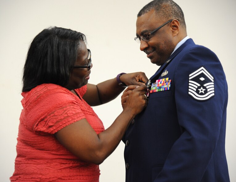 U.S. Air Force Senior Master Sgt. Edward Viverette gets a retirement pin placed on his lapel by his wife Regina during his retirement ceremony on Feb. 6, 2016 at MacDill Air Force Base, FL. Viverette retired after 33 years of military service. (U.S. Air Force photo by Senior Airman Xavier Lockley) 