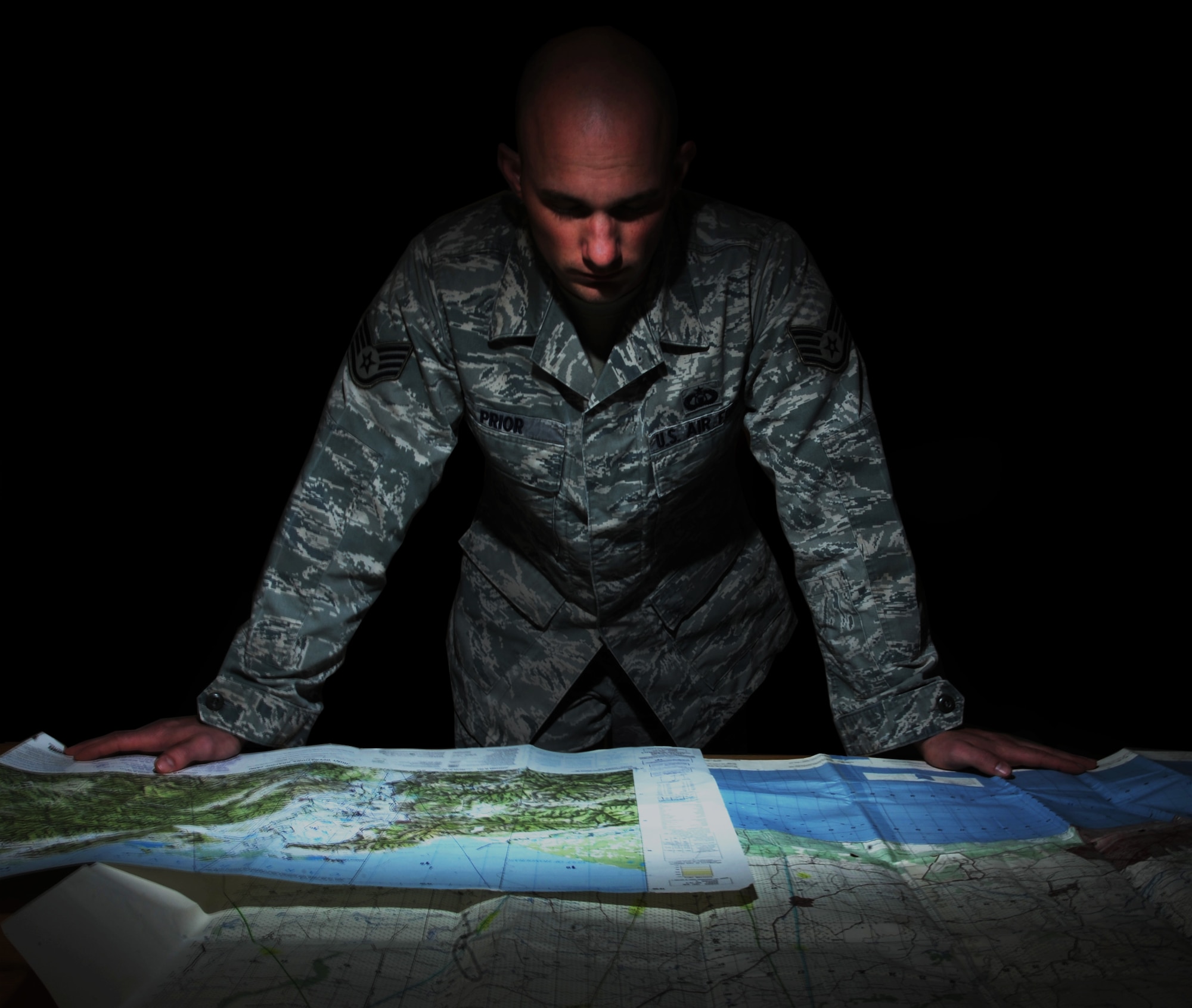 Staff Sgt. Darrell Prior, a Command Terminal Instrument Procedures (TERPS) specialist with Air Mobility Command, examines a map of Columbia at MacDill Air Force Base, Fla., Feb. 2, 2016. As a whole, the MacDill TERPS office ensures all Department of Defense aircraft safely land in Central America, South America, the Caribbean and Mexico by evaluating the host nation’s procedures and applying Air Force criteria. (U.S. Air Force photo illustration by Senior Airman Danielle Quilla)