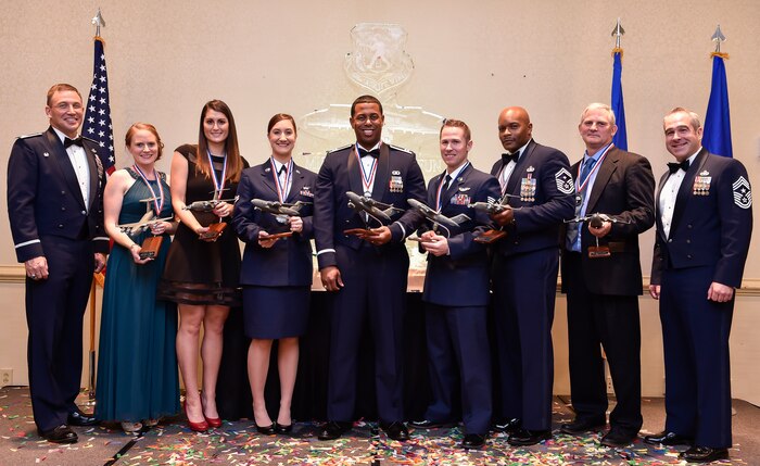 Col. John Lamontagne (left), 437th Airlift Wing commander, and Chief Master Sgt. Kristopher Berg, 437th Airlift Wing command chief (right), pose for a group photo with the annual award winners during the 2nd Annual Golden Globemaster Awards, Feb. 5, 2016, at Joint Base Charleston, S.C. The winners (from left to right) were: Jenna Mattson accepting the senior NCO of the year award  on behalf of her husband Master Sgt. Adam Mattson from the 15th Airlift Squadron, Heather Preston, key spouse of the year from the 437th Aerial Port Squadron, Senior Airman Kayla Zahneis, Airman of the year from the 14th Airlift Squadron, Capt. Ryan Nichols, company grade officer of the year from the 437th Operations Support Squadron, Tech. Sgt. David Flory, NCO of the year from the 16th AS, Senior Master Sgt. Donnel Graham, first sergeant of the year from the 437th Aircraft Maintenance Squadron, Steven Smith, civilian category two from the 437th Maintenance Squadron, and unable to attend was Justin Kessler, civilian category one from the 437th Aerial Port Squadron. (U.S. Air Force photo/Staff Sgt. Jared Trimarchi) 