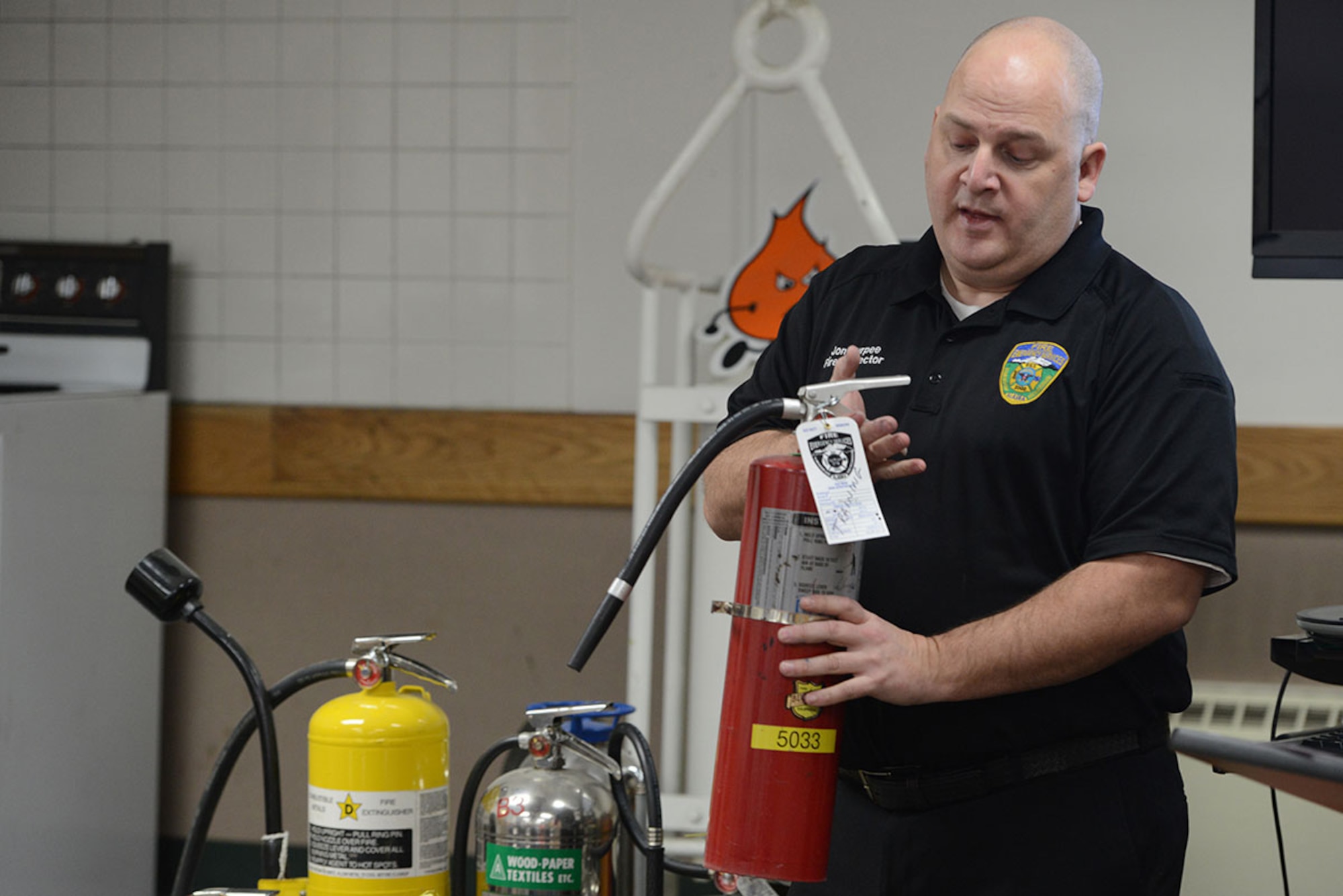 Jon Burpee, 673d Civil Engineer Squadron fire inspector, teaches a class on fire prevention at Fire Station 2, Joint Base Elmendorf-Richardson, Alaska, Feb. 4, 2016. Like a grenade, the first step when utilizing an extinguisher is to pull the pin. (U.S. Air Force photo by Airman 1st Class Javier Alvarez)
