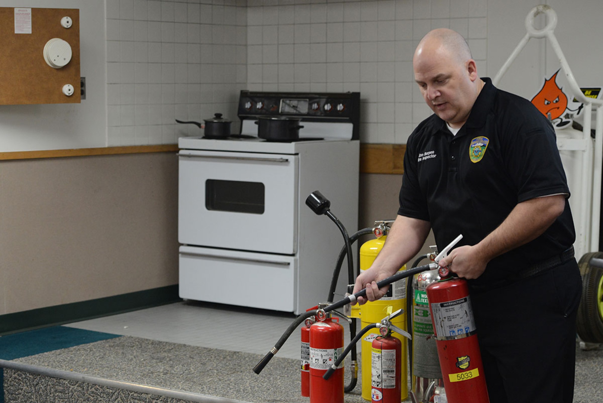 Jon Burpee, 673d Civil Engineer Squadron fire inspector, demonstrates proper use of a fire extinguisher during a fire prevention class at Fire Station 2, Joint Base Elmendorf-Richardson, Alaska, Feb. 4, 2016. Individuals should only attempt to extinguish a fire if it is the size of a small trashcan or smaller and they feel comfortable doing so. (U.S. Air Force photo by Airman 1st Class Javier Alvarez)