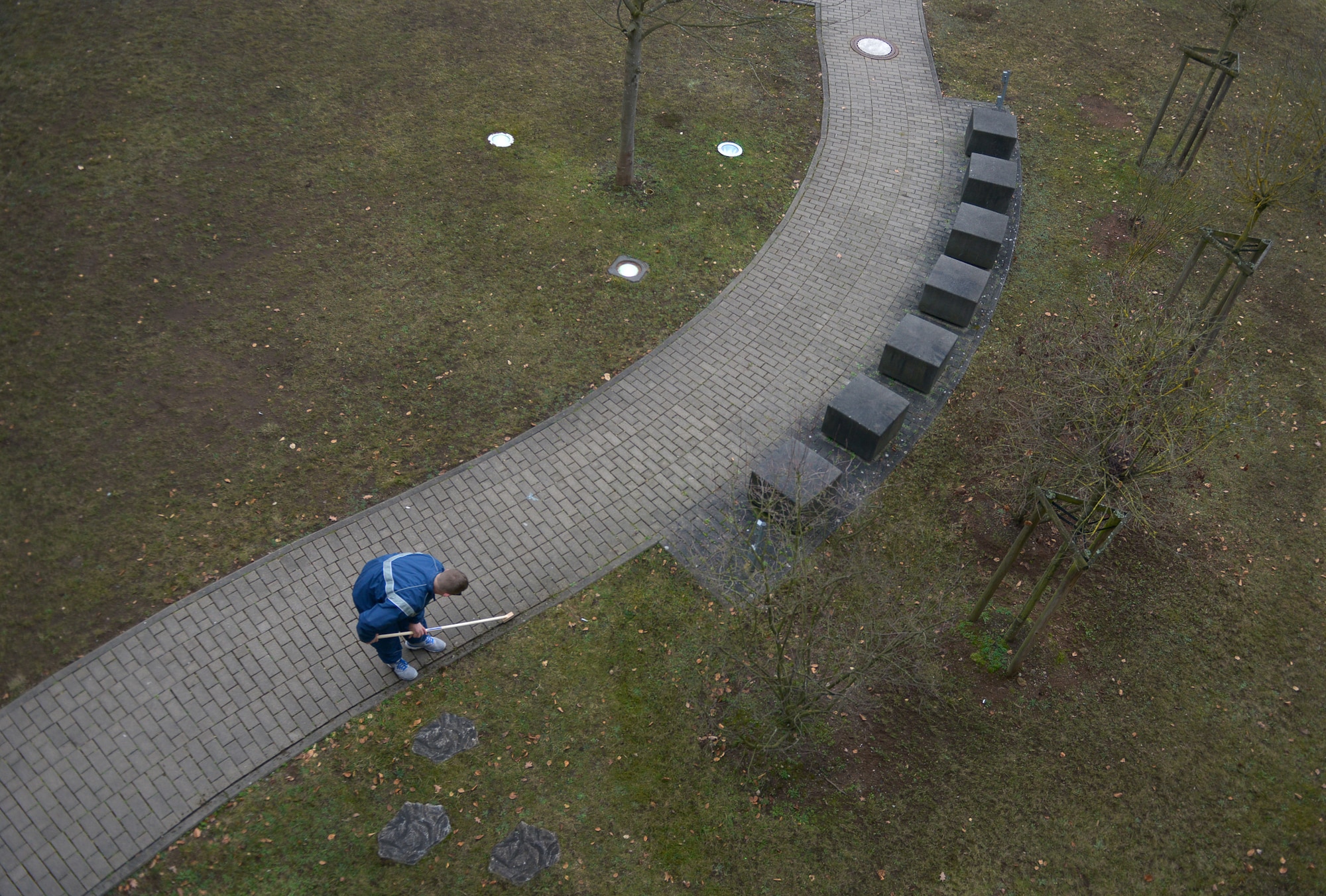 An Airman cleans dirt out from a dormitory walkway’s crevices during a government-issued party Jan. 30, 2016, at Ramstein Air Base, Germany. The clean-up session allowed the base’s renovated bay-orderly program to start off fresh with clean dorms base-wide, which will now have Airmen cleaning up their assigned dorms instead of around the base while on bay orderly. (U.S. Air Force photo/Airman 1st Class Lane T. Plummer)