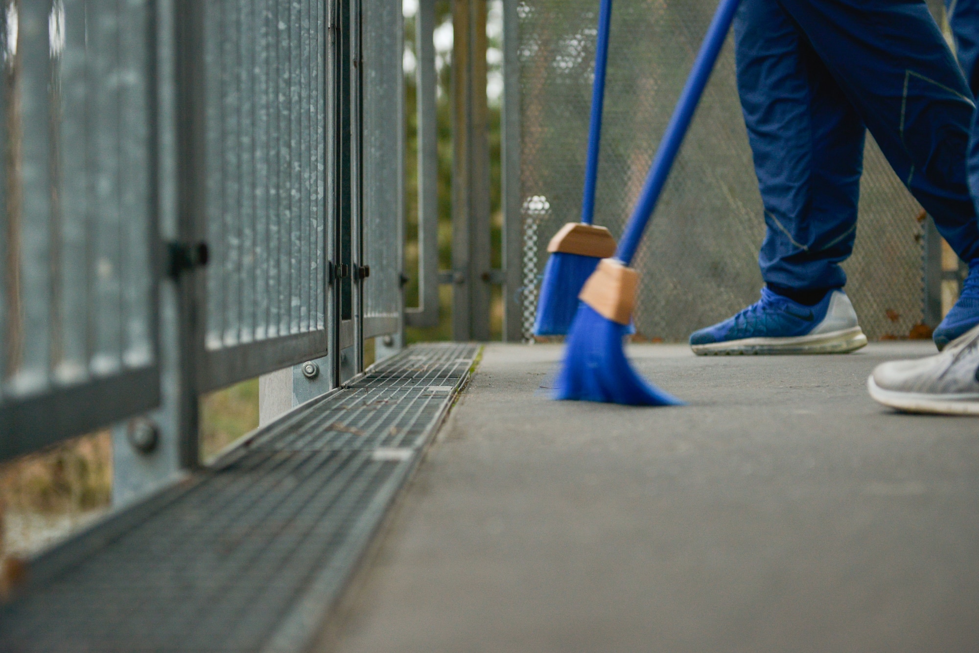 Airmen sweep walkways during a dorm clean-up Jan. 30, 2016, at Ramstein Air Base, Germany. The event allowed the base’s Dorm Reception Center to kick-off the renovated bay-orderly program, which now has Airmen cleaning around their assigned dorms instead of around the base. (U.S. Air Force photo/Airman 1st Class Lane T. Plummer)