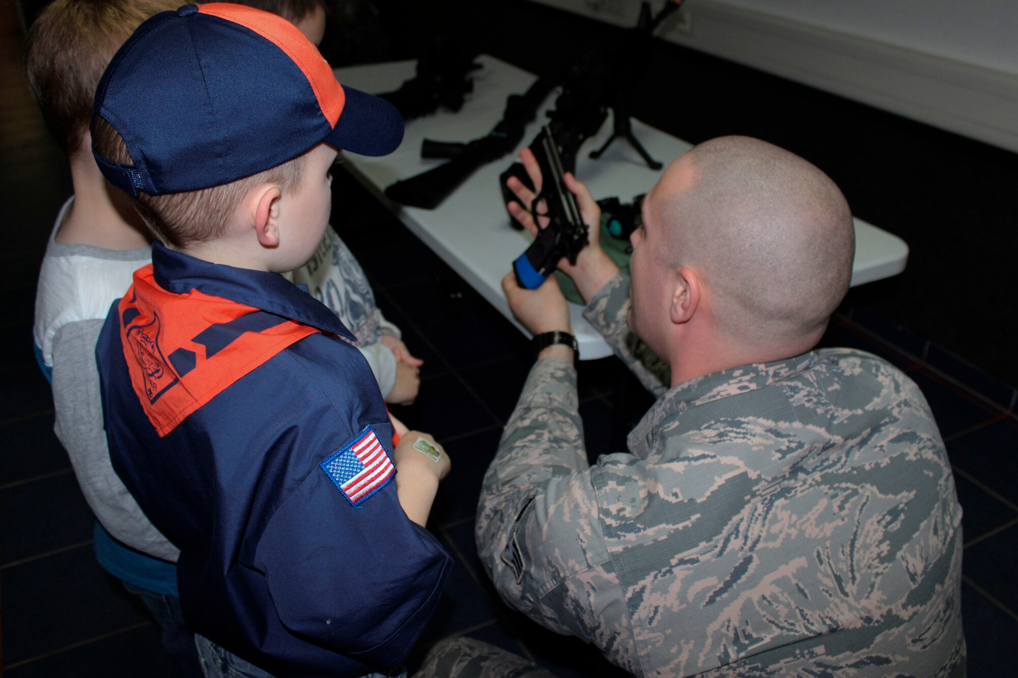 Senior Airman Will Reece 86th Security Forces Squadron Police Services Assistant shows Cub Scouts an M9 pistol Feb. 3, 2016, Ramstein Air Base, Germany. Airmen from the 86th SFS gave local Cub Scouts a tour of their facilities and taught them about some of the weapons they might carry. (U.S. Air Force photo/Tech. Sgt. Robert A. Webb)